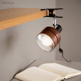 Clip-on spotlight reading lamp above a desk