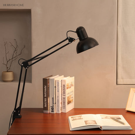 Clip-on reading lamp clamped to a desk edge with the arm extended