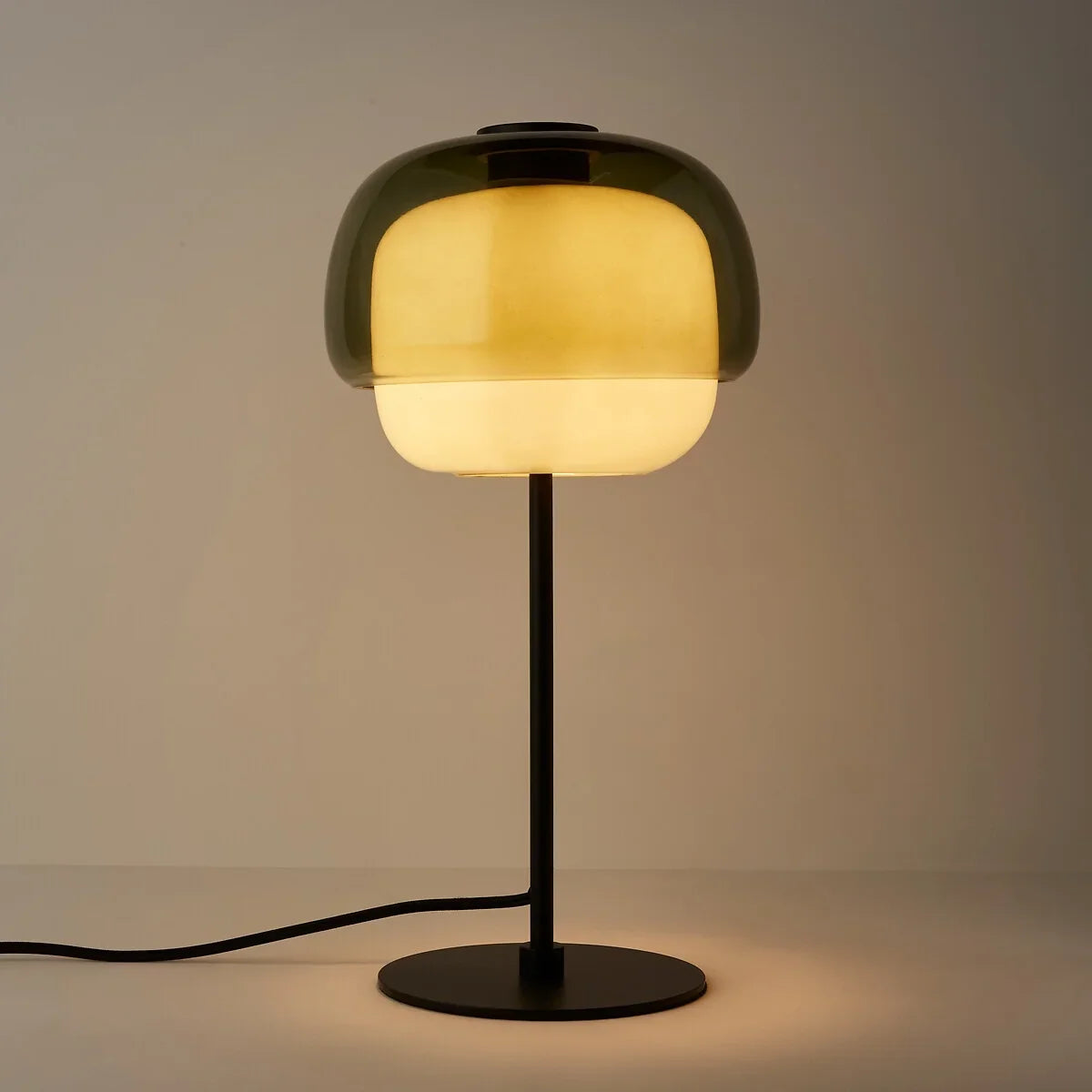 Green colored glass table lamp with rounded shade and slim metal stem