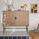 Lit colored glass table lamp set within a cosy styled interior scene
