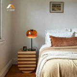 Rounded glass table lamp shade above a black stem and round base