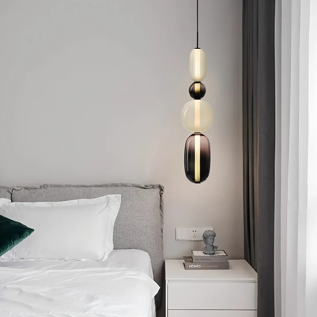 Stacked glass pendant light casting soft light in a modern interior scene