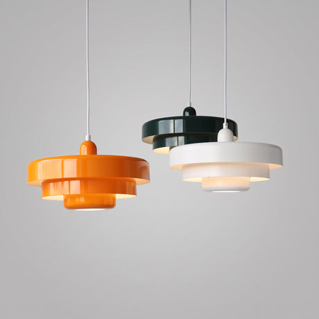 Three tiered pendant lights in orange, dark green and white hanging together