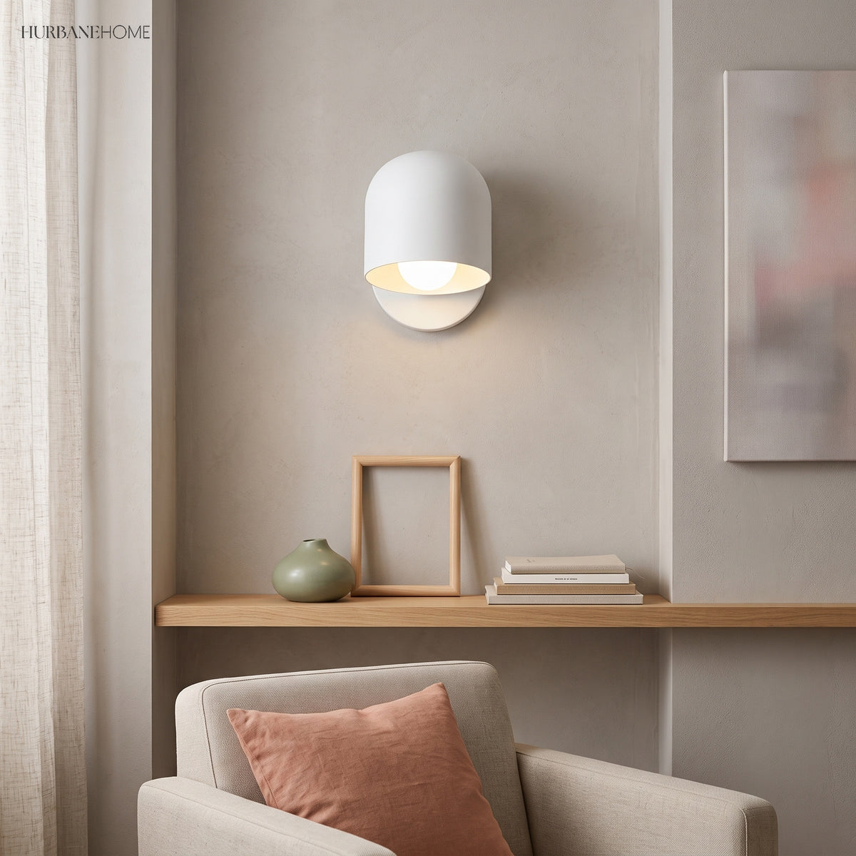 White macaron wall sconce lit above a shelf in a living room