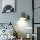 Green macaron sconce throwing a soft pool of light down a plain wall