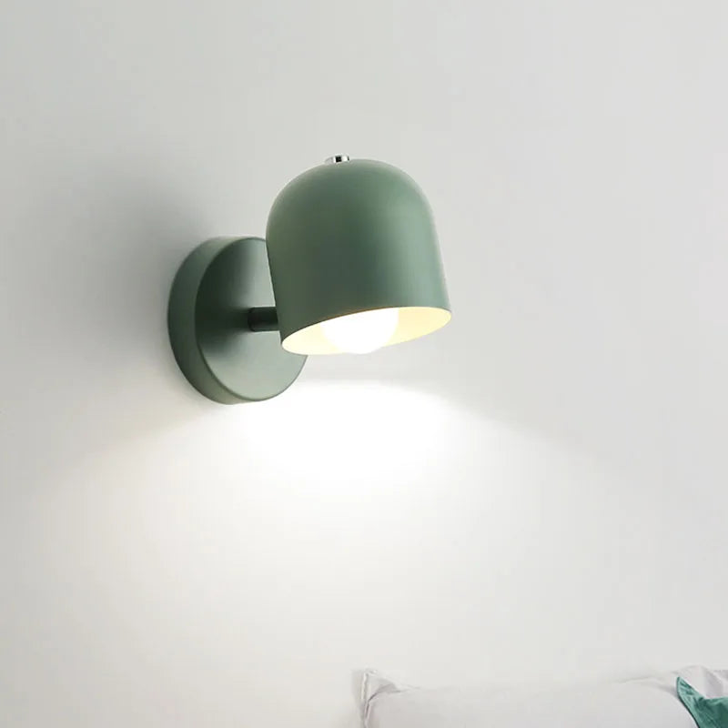 Grey macaron sconce lit beside a vase of flowers on a side table
