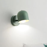Grey macaron sconce lit beside a vase of flowers on a side table