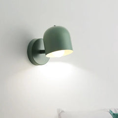 Grey macaron sconce lit beside a vase of flowers on a side table