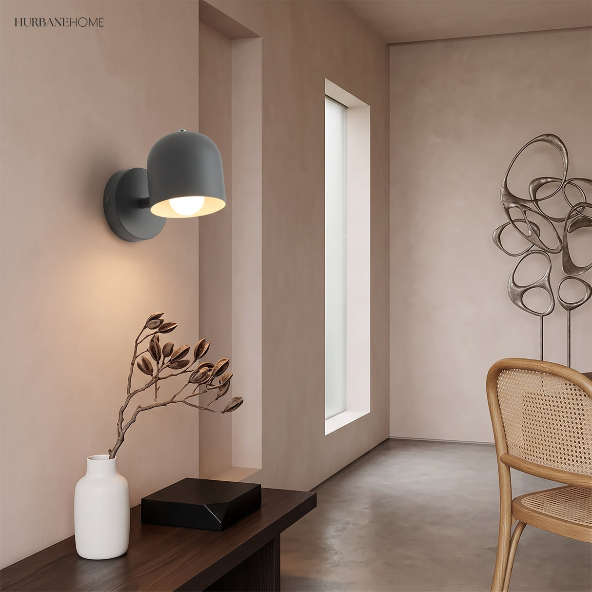 Grey macaron wall sconce lit in a narrow hallway beside a window