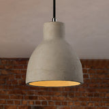 Cement barn pendant lit in front of a red brick wall