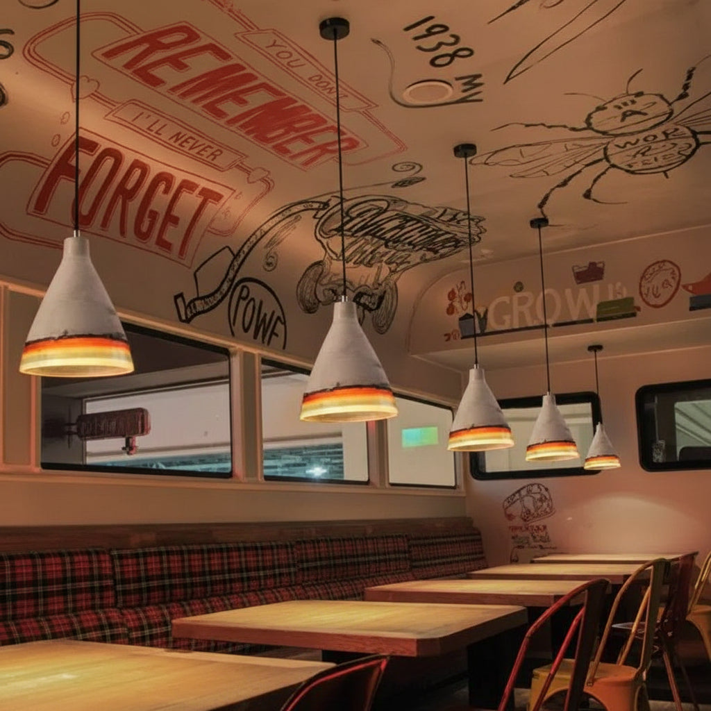 Four cement cone pendants lit above booth seating in a diner