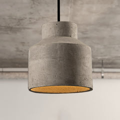 Two stepped cylinder cement pendants lit against a concrete wall