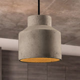 Stepped cylinder cement pendant against a warm marbled stone wall