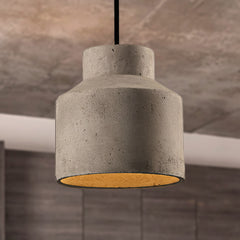 Stepped cylinder cement pendant against a warm marbled stone wall