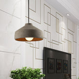 Wide cement dome pendant lit against a patterned white feature wall