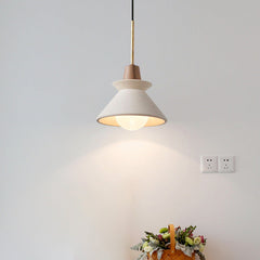Cone pendant lit above a flower arrangement on a grey wall