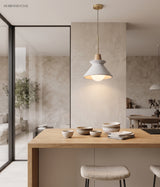 Cone pendant lit over a kitchen island with stools and bowls