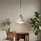 White cement cone pendant lit above a console table and dried grasses