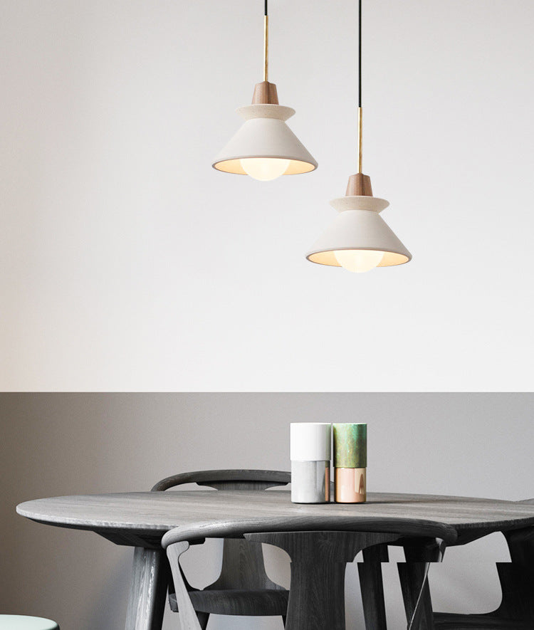 Pair of cement cone pendants above a round dining table