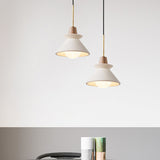 Two cement cone pendants lit at different heights on grey