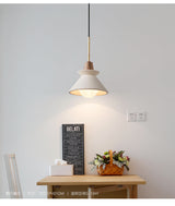 Cone pendant lit over a table beside a small chalkboard sign