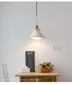 Cone pendant lit over a table beside a small chalkboard sign