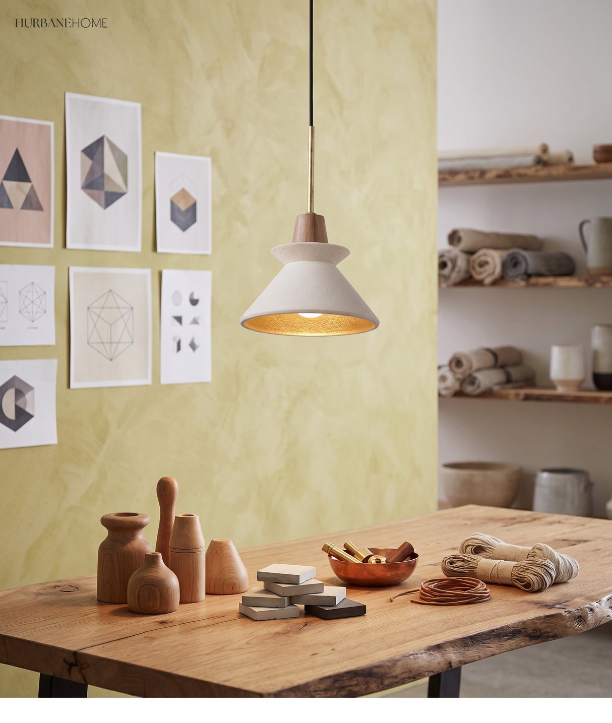 Cement cone pendant over a timber table against a yellow wall