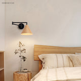 Cone shade swing arm wall sconce in a styled bedroom