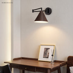 Cone shade swing arm wall sconce above a desk
