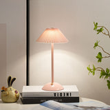 Gold cordless table lamp shown at an angle with slim stem and domed base