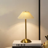 Full-height gold table lamp with tall pleated shade on white