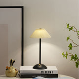 Warm glow escaping the pleats of the lit gold table lamp shade