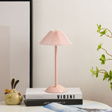 Soft pink table lamp with matching pleated shade on a side table