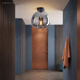 Smoke glass semi flush light in a blue and copper toned hallway