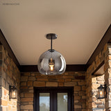Smoke glass semi flush light on a covered stone porch