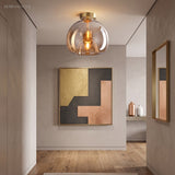 Amber glass semi flush light in a hallway with framed artwork