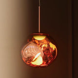 Close view of the lit copper shade showing light breaking through the moulding