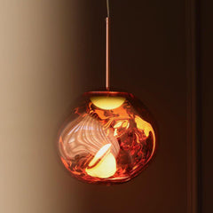 Close view of the lit copper shade showing light breaking through the moulding
