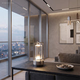 Black cordless lamp on a low table in a glass walled apartment at dusk