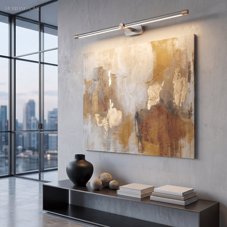 Black and brass linear light lit above a round mirror in a tiled bathroom