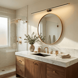 Brass linear light above a framed mirror in a bathroom with double basins