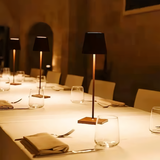 A row of cordless lamps lighting a long set banquet table