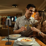 Couple dining at a table lit by a black cordless lamp