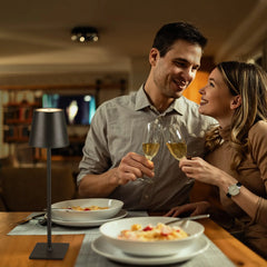 Couple dining at a table lit by a black cordless lamp