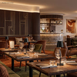 Cordless lamps on set restaurant tables in a warm dining room
