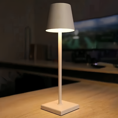 White cordless table lamp lit against a dark evening background