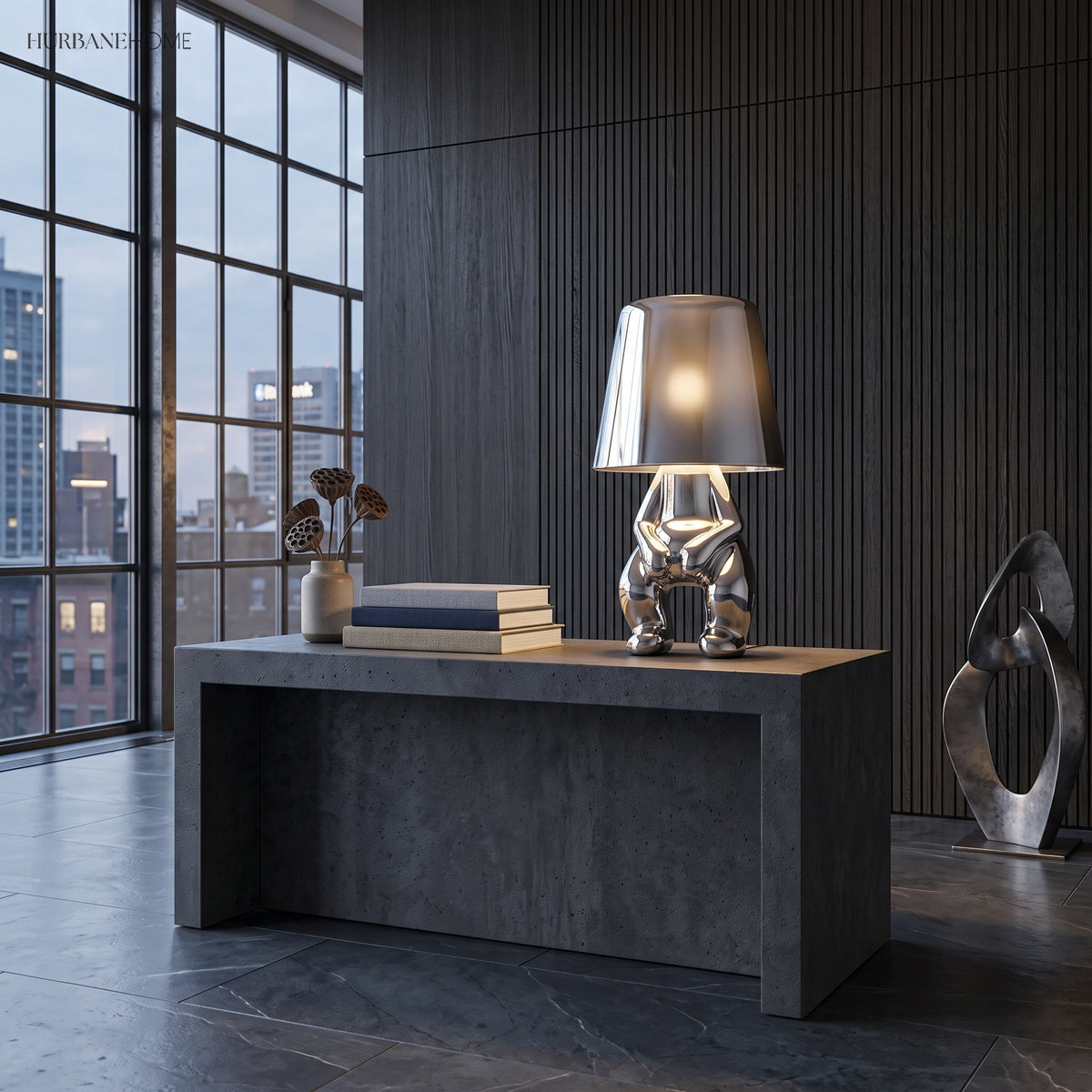 Silver figurine table lamp lit on a dark stone kitchen island