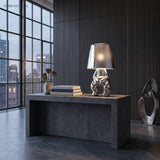 Silver figurine table lamp lit on a dark stone kitchen island