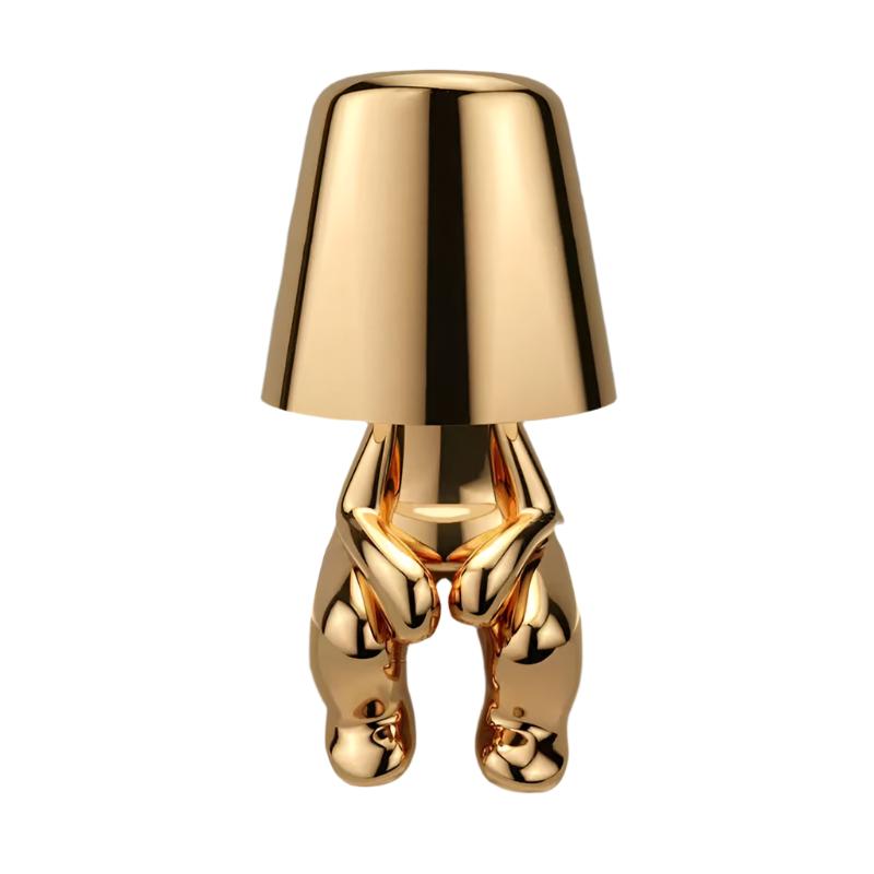 Gold figurine lamp standing to attention beneath the tapered shade