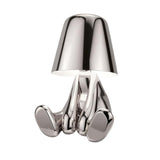 Silver figurine lamp seated with its legs stretched out in front